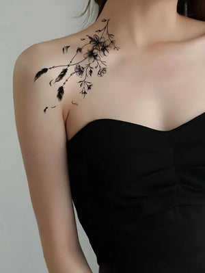 Woman wearing an elegant floral temporary clavicle tattoo in black dress, showcasing neckline sophistication