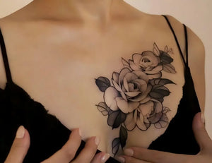 Woman with floral temporary breast tattoos wearing a black top.