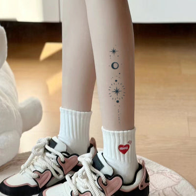 Leg with sun, moon, and stars tattoo, showing off bold, intricate body art with an adventurous vibe.