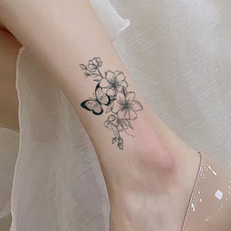 Elegant butterfly and flower tattoo design on ankle, symbolizing freedom and beauty.