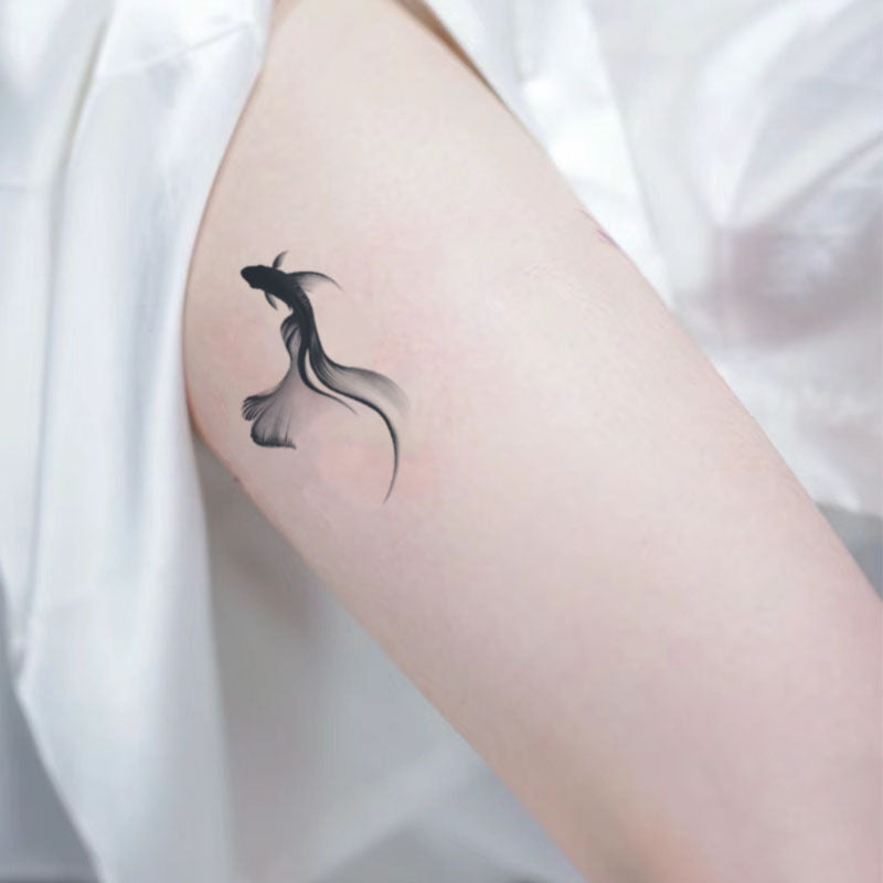 Minimalist koi tattoo on arm, representing tranquility and harmony through simplified forms and calming negative space.